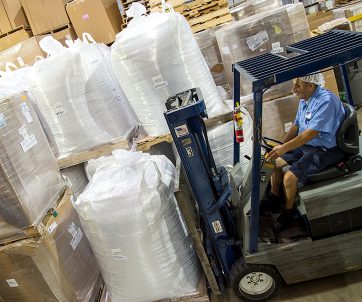 Warehouse worker loading crates with with a forklift